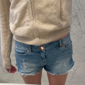 Blå jeansshorts från Only - Säljer ett par snygga blå jeansshorts från Only med fransiga kanter och slitna detaljer storlek xs