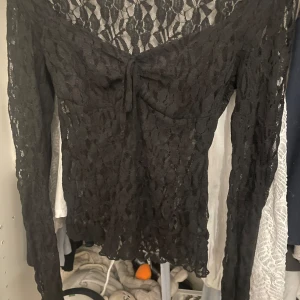 Svart spetsblus med knyt framtill - Från nelly egentligen men köpt på vinted för 180kr. Säljer pga den va för stor för mig. Säljer billigt eftersom att den va lite trasig men annars e den perfekt  skick