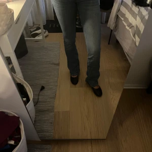 M ljusblå bootcut jeans - Säljer ett par klassiska jeans i ljusblå tvätt. Jeansen har bootcut-ben och snygga kontrastsömmar. De är högmidjade och har en rak passform upptill som går ut lite nertill. Perfekta för dig som gillar en tidlös denimlook.