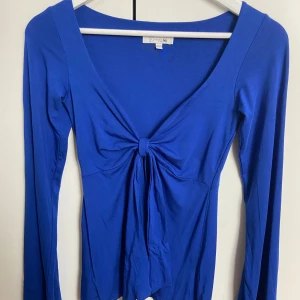 Blå långärmad topp med knyt - Supersnygg blå långärmad topp från Designbysi. 