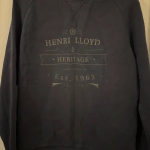 Mörkblå sweatshirt från Henri Lloyd - Snygg mörkblå sweatshirt från Henri Lloyd med tryck på bröstet.