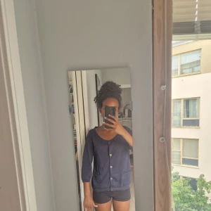 Mörkblå blus/tröja med knappar - Jag säljer den här mörkblåa blus/ tröja som jag har använt 2 gånger. Jag köpte den på en secon hand, den är i storlek s men passar som m också.