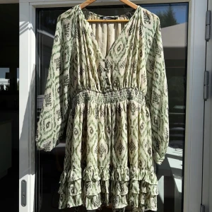 Grönmönstrad volangklänning från Zara - Supersöt volangklänning från Zara med grönt och beige mönster, v-ringning med smock i midjan. Finns inte kvar på Zaras hemsida. SOM NY! ändast använd förra midsommar 💛💚