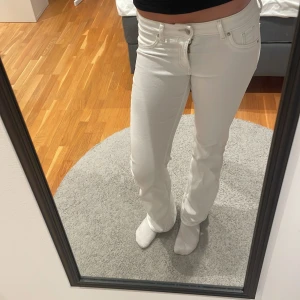 Vita bootcut jeans från &Denim  - Snygga vita bootcut jeans från &Denim i storlek 34. Modellen har låg midja och klassisk femficksdesign. Materialet är mjukt och stretchigt för extra komfort. Köparen står för frakten 
