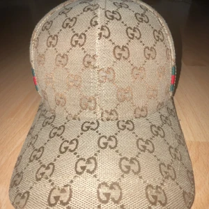 Gg keps - Helt ny oanvänd Gg keps. Fin fräsch beige färg med grön o röd detaljer på bege sidorna