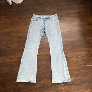 Ljusblå bootcut jeans från Divided - Säljer ett par ljusblå bootcut jeans från Divided i storlek 42. Jeansen har klassisk femficksdesign, lågmidjade upptill och utsvängda ben/ bootcut . 
