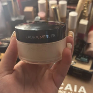 Laura Mercier löspuder - Translucent löspuder från Laura Mercier i en rund burk med svart lock. Perfekt för att fixera sminket och ge en matt finish. Puder i ljus, neutral nyans som passar de flesta hudtoner. Typ helt ny kvitto och förpackning finns