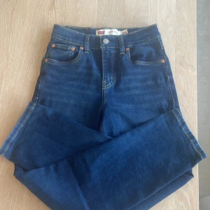 Levi's Loose Taper jeans blå 12A - Snygga blå Levi's Loose Taper jeans i klassisk denim med fem fickor och kontrastsömmar. Modellen har en loose fit upptill och smalnar av nedtill för en modern look. Perfekta för dig som gillar avslappnad stil med lite edge.