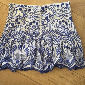 Vit och blå broderad kjol från Zara - Supersöt kortkjol från Zara i vitt med blått broderat mönster. Knappt använd så den är i väldigt bra skick 