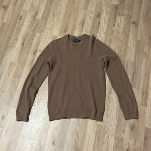 Brun stickad tröja från Riley - Säljer en brun stickad tröja från Riley i storlek S. Tröjan har rund halsringning, långärmad passform och är ribbstickad vid ärmslut och nederkant. Perfekt för dig som gillar en enkel och stilren look.