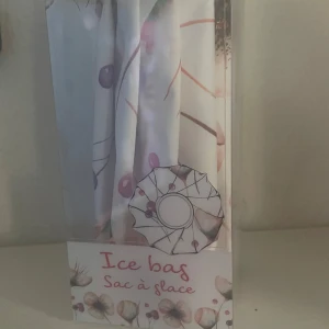 Blommig ice bag för kylning - Säljer en söt ice bag med blommigt och prickigt mönster i pastellfärger. Perfekt att fylla med is och använda på ömma eller smärtande områden. Väskan har skruvlock och är lätt att använda. Aldrig använt, fick den i en mystery box.