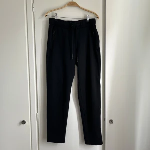 Svarta mjukisbyxor - Svarta mjukisbyxor från Crivit med dragsko i midjan och dragkedjefickor på sidorna. Byxorna har en rak passform och är tillverkade i mjukt material som är perfekt för chill eller träning. Snygg och enkel design som funkar till det mesta.