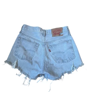 Levi's ljusblå jeansshorts med fransar - Ljusblå jeansshorts från Levi's, modell 501, fint skick. Midjemått: 33cm