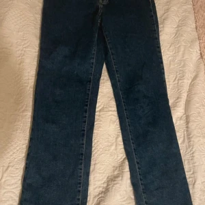 Mörkblå raka jeans - Snygga mörkblå jeans med rak passform och klassisk femficksdesign. Jeansen har en enkel look utan slitningar och är perfekta för dig som gillar en tidlös look. Aldrig använda.