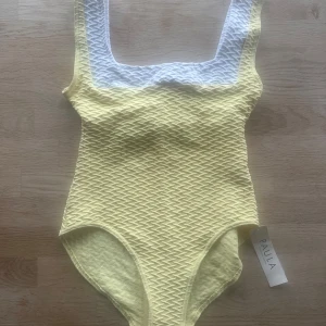 Gul baddräkt från PAULA Stockholm - 🟡PAULA baddräkt – modell “Swordfish” i färgen SUN (storlek L) Nypris: 1499 kr i affär. Superfin och smickrande baddräkt från svenska märket PAULA Stockholm Sweden. Färgen heter “Sun” – en mjuk, ljusgul ton som framhäver solbrännan! Det vita partiet upptill ger en snygg kontrast och den strukturerade stretchtyget formar sig riktigt fint efter kroppen. ✅ Oanvänd, med originaltaggar & hygienisk skyddsplast kvar ✅ Tjockt, följsamt tyg i hög kvalitet ✅ Skön passform – sitter på plats.