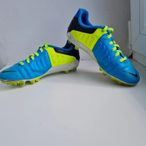 Nike fotbollsskor AG strl 32 - Använda men i mycket bra skick. Till för spel på konstgräs. Storlek 32.