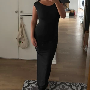 Klänning med öppen rygg - En fin svart långklänning med öppen rygg. Den är oanvänd.