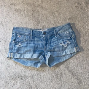 Blå jeansshorts från Hollister - Säljer skit snygga blåa jeansshorts från Hollister. Säljer för att de är för stora för mig. Shortsen är i hyfsat bra skick (lite tecken på användning)! Midjemåttet: 43cm. Hör av er vid frågor och funderingar💓
