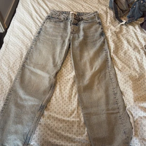 Gråa raka jeans från ASOS DESIGN - Säljer ett par gråa jeans från ASOS DESIGN med rak passform och klassisk femficksdesign. Jeansen har normal midja och är tillverkade i bomull. Perfekta för dig som gillar en avslappnad och stilren look.