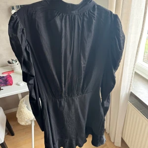 Svart kortklänning med puffärm - Svart kortklänning med markerad midja och snygga puffärmar. 