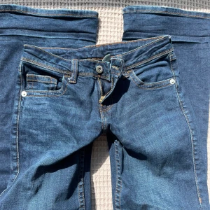 Blå jeans med broderade bakfickor - Midjemått: 37cm innerbenslängden: 79cm💗