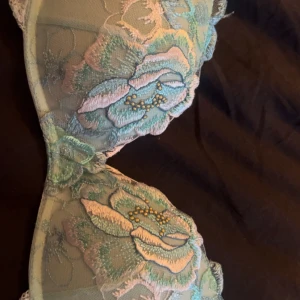 Blommig pastellfärgad bh, från Intimissimi(gioa flower push up) - Supersöt bh i pastelliga toner med broderade blommor i blått, grönt . Toppen har vadderade kupor och spetsdetaljer längs kanterna. Perfekt för dig som vill ha något unikt och romantiskt i garderoben.
