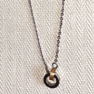 Halsband från Bud to Rose med ringar - Snyggt halsband från Bud to Rose med en silverkedja och ett hängsmycke i form av två ringar, en silver  och en glittrig guld.