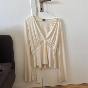 Vit topp, strl L  - Vit topp med V-Urringning och spetsdetalj. Orginellt från Gina tricot. Säljer pågrund av att den inte kommit till användning och pågränsen till förstor. 