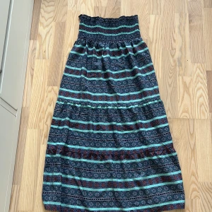 Mönstrad långkjol i blått och turkos - Säljer en långkjol med elastisk midja och snyggt mönster i blått, turkos och inslag av rött.  Perfekt för dig som gillar färg och mönster. Superbekväm och lätt att styla!