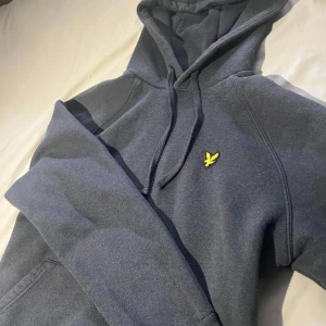 Lyle&scott hoodie - Säljer en mörkgrå hoodie från Lyle & Scott, bra skick o väldigt skön passar dom flesta stilarna så som casual och grisch