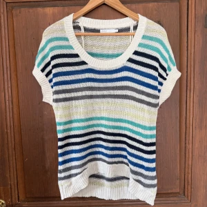 Randig stickad topp från ONLY - Snygg stickad topp från ONLY med korta ärmar och rund hals. Randigt mönster i vitt, grått, blått, svart, turkost och ljusgult. Perfekt för vår och sommar, lätt och luftig med ribbade kanter. Går och styla snyggt!