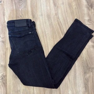 Svarta G-Star RAW 3301 straight jeans - Snygga svarta jeans från G-Star RAW, modell 3301 Straight. Klassisk femficksdesign, raka ben och diskret logga på bakfickan. Jeansen är i ett mörkt tvättat denimtyg och har en stilren look som passar till det mesta.