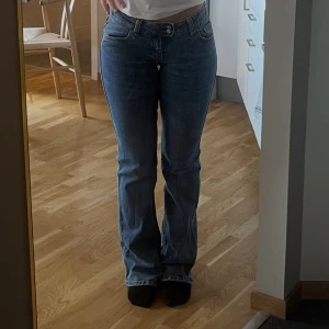 Blå bootcut jeans low waist - Säljer ett par blå jeans med bootcut.  Är lite långa på mig som är 170 cm lång. Vanliga fickor bak. Något Ljusare än på bilden