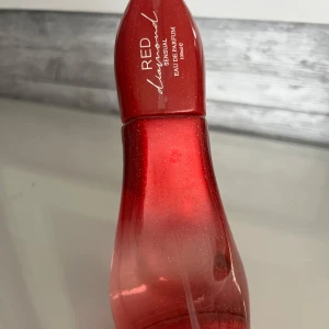 Red Diamond Sensual parfym 100ml - Red Diamond Sensual Eau de Parfum i en unik röd glittrig flaska formad som en högklackad sko. Flaskan är tillverkad i glas med en snygg övergång från mörkrött till ljusare rött. Rymmer 100 ml och är en riktig statement-piece på parfymhyllan.