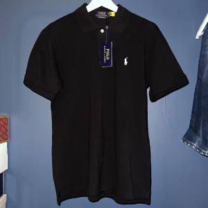 Svart pikétröja från Polo Ralph Lauren - Svart polo skjorta helt oandvänd med lapp.   Priset är ej hugget i sten.