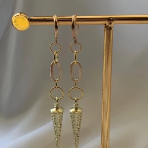 Guldiga kedjeörhängen med koner - Snygga örhängen i guldton med kedjor och coola konformade hängen. Kedjorna har både runda och ovala länkar som ger ett trendigt uttryck. Perfekta för dig som vill sticka ut med accessoarer som har attityd.