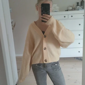Beige kofta från H&M med knappar - Supermjuk beige kofta från H&M i storlek S. Koftan har oversized passform, stora bruna knappar framtill och långa ärmar med breda muddar. Perfekt för lager-på-lager och chill vibes. Materialet är stickat och känns riktigt cozy. Jätteskön och oanvänd, skulle säga att den är lite mer korallfärgad i verkligheten💗Skriv för funderingar 