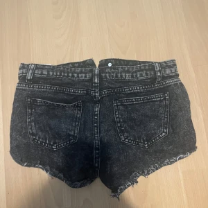 Svarta jeansshorts med slitningar - Snygga svarta jeansshorts från Gina Tricot med råa, fransiga kanter och slitningar framtill. Klassisk femficksmodell med dragkedja och knapp. Perfekta för en cool och avslappnad stil i sommar💕💕
