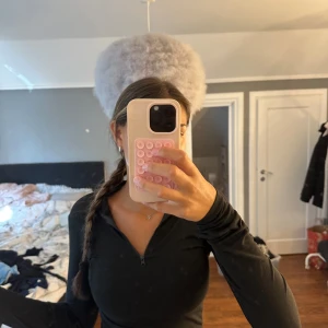 Svart långärmad half zip tröja - Svart långärmad tröja med half zip-dragkedja framtill. Tröjan har en tight passform och hög krage, perfekt för lager-på-lager eller som den är. Enkel och stilren design som funkar till många olika looks. Litet hål som syns på bild 2