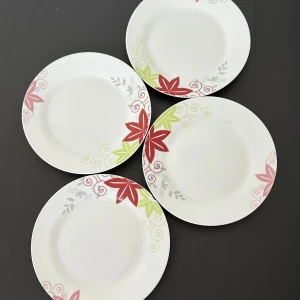 4-pack blommiga tallrikar  - Fin serveringsbricka från Boxxx. Höjd 3 cm, längd 20 cm. I fint skick med – lite missfärgning och en liten spricka (se bilder).  Perfekt att använda vid servering av tårtor, kakor, bakverk eller andra mindre maträtter. Passar fint till både vardag och fest – stilren och enkel design som lyfter dukningen.