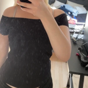 Svart kortärmad topp från BikBok - En stilren svart topp från BikBok i storlek S. Modellen är enkel med korta ärmar och rund hals, perfekt att matcha med jeans eller kjol. Tidlös design som funkar till många olika looks.