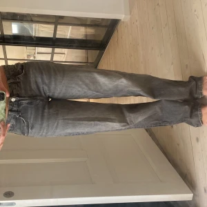 Grå raka jeans från Zara, strl 34 - Grå jeans från Zara i storlek 34 med rak passform och klassisk femficksdesign. Jeansen har en något tvättad look och normal midja. Tillverkade i bomullsmaterial och passar perfekt till en avslappnad stil.