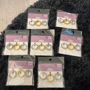 Set med ringar i silver och guld från Ztiz - Flera set med trendiga örhängen från Ztiz. Varje förpackning innehåller tre par ringar i olika stilar: två i silverfärg och en i guld. Ringarna har coola detaljer som små kulor och mönstrad yta. Perfekt för att mixa och matcha till din egen vibe. Allt för 40kr