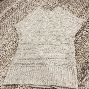 Beige stickad tröja från Lindex - Supermysig beige stickad tröja från Lindex i storlek XS. Tröjan har korta ärmar, ribbad hals och nederkant samt ett snyggt strukturerat mönster. 