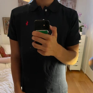 Marinblå pikétröja Polo Ralph Lauren - Snygg marinblå pikétröja från Polo Ralph Lauren i custom slim fit. Köpt i USA,, Helt oanvänd med lappen kvar.