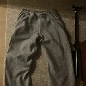 Grå mjukisbyxor med resårmidja - Mysiga grå mjukisbyxor med resår i midjan och avslappnad passform. Perfekta för chill dagar hemma eller när du vill vara bekväm. Klassisk look utan synliga loggor eller detaljer.