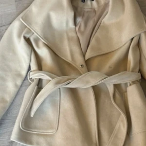 Beige kappa från Vero Moda - Snygg beige kappa från Vero Moda med ett effektivt bälte i midjan. Köpt för någon månad sen men den inte har använts speciellt mycket! Hör av dig vid intresse!!🥰🥰❤️‍🔥 pris kan diskuteras!