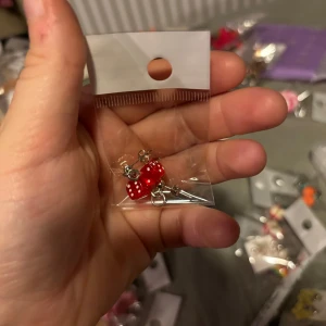 Röda örhängen med prickar - Säljer ett par söta röda örhängen med vita prickar. De har en charmig design och är perfekta för att lägga till en färgglad touch till din outfit. Kommer i en praktisk förpackning.