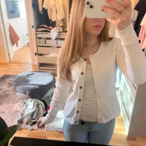 Vit kofta med knappar - jätte fin vit kofta med bruna knappar, passar perfekt till nästan allt! storleken står inte på så jag vet inte, men jag bär oftast s! 