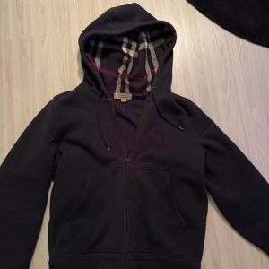 Burberry hoodie - Säljer en Burberry hoodie i storlek S! Skick 8/10 (replacement på handtag dragkedjan) har ni frågor är de bara o höra av sig!😊😊